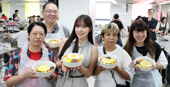  치어리더 이다혜가 18일 전북 전주시 한국전통문화전당에서 대만 팬들과 함께 비빔밥 만들기 체험을 하고 기념촬영을 하고 있다. 전북 출신 이다혜 치어리더는 오늘 완주 대승한지마을에서 전북특별자치도 관광홍보대사로 위촉된다. [뉴스1]