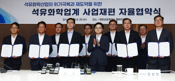 김정관 산업통상자원부 장관(오른쪽 다섯째)이 20일 대한상공회의소에서 열린 ‘석유화학업계 사업 재편 자율협약식’에 참석해 업계 관계자들과 기념촬영을 하고 있다. 김 장관은 “석유화학 산업이 미래 경쟁력을 갖기 위해서는 과감하고 신속한 구조 개편만이 유일한 돌파구”라고 말했다. [뉴스1]