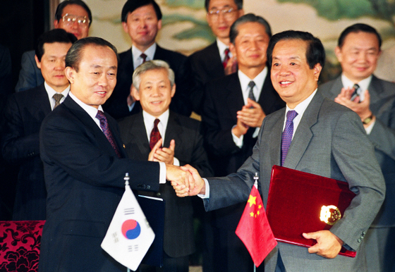 1992년 8월 24일 한국의 이상옥 외무장관(왼쪽)과 중국의 첸치천 외교부장이 중국 베이징 댜오위타이(釣魚臺) 국빈관에서 ‘한·중 외교관계 수립에 관한 공동성명서’를 교환한 뒤 악수를 나누고 있다. [연합뉴스]