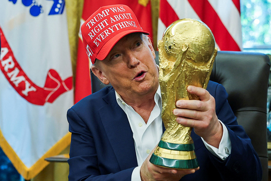 도널드 트럼프 미국 대통령이 22일(현지시간) 워싱턴DC 백악관에서 열린 국제축구연맹(FIFA) 북중미 월드컵 조추점 일정 발표 행사에서 월드컵 우승 트로피를 들어보이고 있다. 로이터=연합뉴스