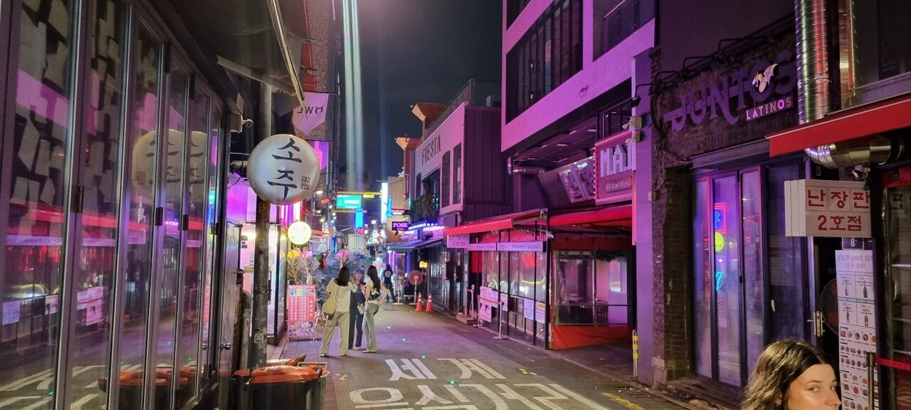 한유정(가명·26)씨가 일하는 이태원 해밀턴 호텔 뒷골목에 행인들이 모여 있다. 부모의 자살 후 한씨는 여기에서 거주하며 새로운 사람들을 사귀기 시작했다. 사진 속 인물들은 기사 본문과 관계 없음. [중앙포토]