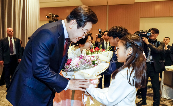 이재명 대통령과 김혜경 여사가 24일(현지시간) 미국 워싱턴DC의 한 호텔에서 열린 재미동포 만찬 간담회에서 화동으로부터 꽃다발을 받고 있다. 대통령실사진기자단 