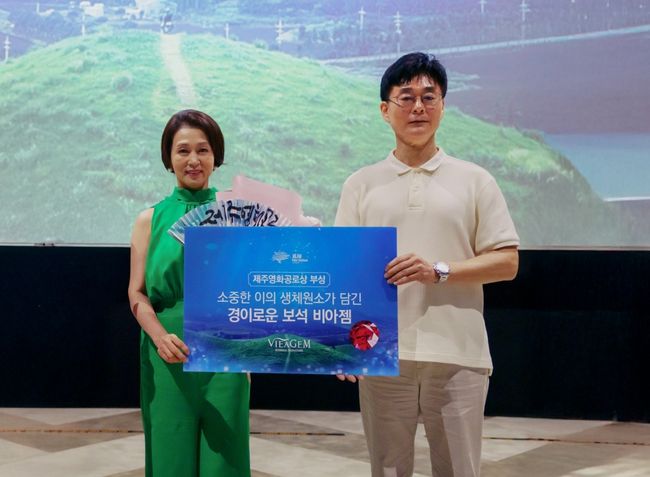 최필재 비아생명공학 대표이사(오른쪽)가 배우 문희경에게 제주영화제 공로상을 시상하고 생체보석‘비아젬’부상과 함께 기념사진을 촬영하고 있다. / 사진제공=보람그룹