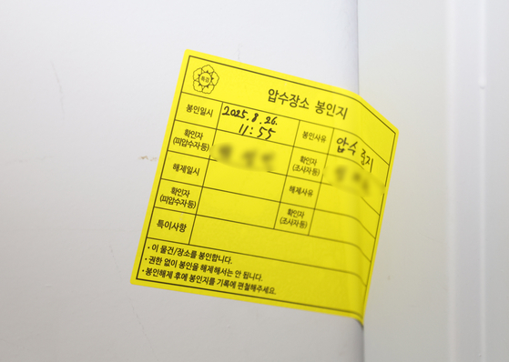 내란 특검팀이 26일 인천 연수구 해양경찰청에 대한 압수수색에 나선 가운데 회의실 출입문에 압수장소 봉인지가 붙어 있다. 연합뉴스