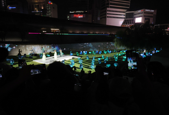 7월 31일 DDP에서 '서울라이트 DDP 2025 여름'을 찾은 시민들이 미디어아트와 개막 패션쇼를 관람하고 있다. 연합뉴스