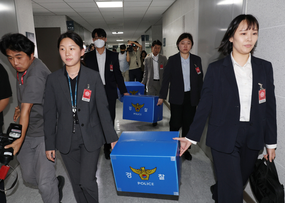 서울경찰청 금융범죄수사대 전담수사팀 관계자들이 11일 주식 차명거래 혐의를 받는 이춘석 의원의 국회 사무실 압수수색을 마친 뒤 압수품을 들고 의원실을 나서고 있다. 연합뉴스