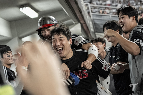 지난 24일 KIA전에서 6회 역전 득점을 기록한 LG 신민재(위)가 더그아웃에 돌아오자 업어주며 환호하는 김현수(아래)와 동료들. 후반기 8할대 승률을 유지 중인 LG는 정규리그 조기 우승에 도전 중이다. [사진 LG 트윈스 페이스북]