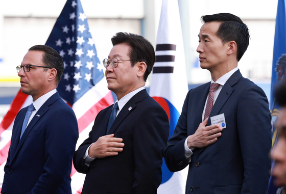 이재명 대통령이 26일(현지시간) 미국 필라델피아에 위치한 ‘한화 필리조선소’에서 열린 미국 해양청이 발주한 국가안보다목적선 ‘스테이트 오브 메인(State of Maine)’호의 명명식에서 국민의례를 하고 있다. 사진 왼쪽부터 조시 샤피로 펜실베니아 주지사, 이대통령, 김동관 한화그룹 부회장. 김현동 기자