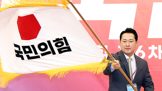 국민의힘 장동혁 신임 당 대표가 26일 서울 여의도 국회도서관에서 열린 제6차 전당대회 결선에서 당 대표로 선출된 뒤 당기를 흔들고 있다. 국회사진기자단