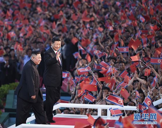 시진핑 중국 국가주석이 지난 2019년 6월 20일 북한 5.1 경기장에 운집한 10만 평양 시민에 손을 들어 인사하고 있다. 시 주석 뒤를 따르는 김정은 북한 국무위원장의 발걸음은 '시 주석 띄우기'의 대표적 모습이다. [중국 신화망 캡처]