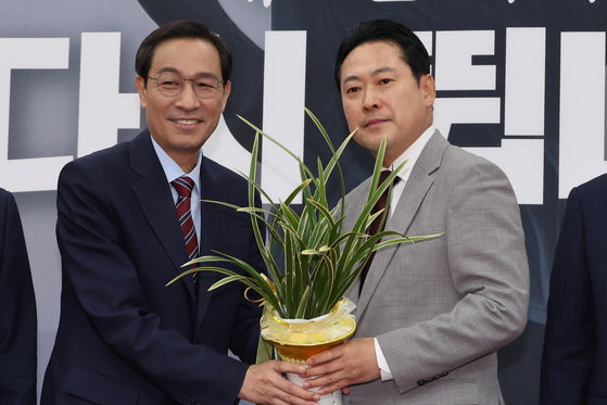 장동혁 국민의힘 대표(오른쪽)가 27일 우상호 정무수석으로부터 축하난을 받고 있다. [뉴시스]