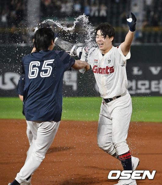 [OSEN=부산, 이석우 기자] 28일 부산 사직야구장에서 2025 신한 SOL 뱅크 KBO 리그 롯데 자이언츠와 KT 위즈의 경기가 열렸다. 홈팀 롯데는 감보아가, 방문팀 KT는 헤이수스가 선발 출전했다.롯데 자이언츠 고승민이 연장 11회말 2사 만루 끝내기 안타를 치고 축하 물세례를 받고 있다. 2025.08.28 / foto0307@osen.co.kr