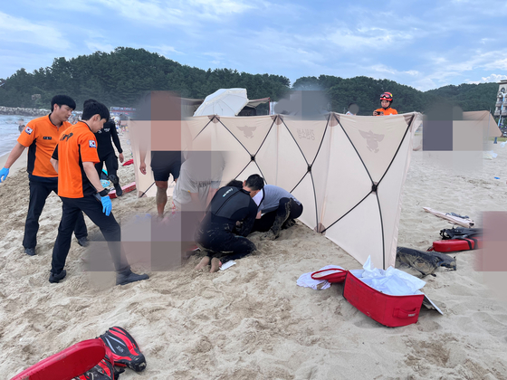 강릉의 하조대 해수욕장에서 30일 익수자를 구하려다 되레 물에 빠진 20대 여성을 심폐소생술(CPR) 하는 강릉해경과 소방 당국. 사진 강릉해경