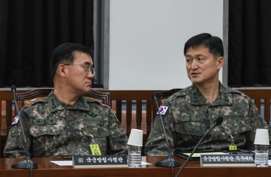 여인형 국군방첩사령관(왼쪽)과 이경민 방첩사령관 직무대리가 지난해 12월 7일 오전 서울 여의도 국회에서 열린 정보위원회 전체회의에 출석해 대화를 나누고 있다. 뉴스1
