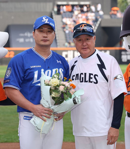 삼성 오승환(왼쪽)이 은퇴 투어 때 김경문 한화 감독으로부터 꽃다발을 받은 뒤 기념 사진을 찍고 있다. /한화 이글스 제공