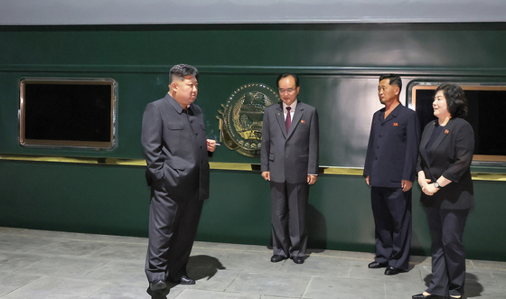 김정은 북한 국무위원장이 전용 열차 앞에서 담배를 피우며 최선희 외무상을 비롯해 조용원·김덕훈 당 비서와 대화하는 모습. 노동신문=뉴스1