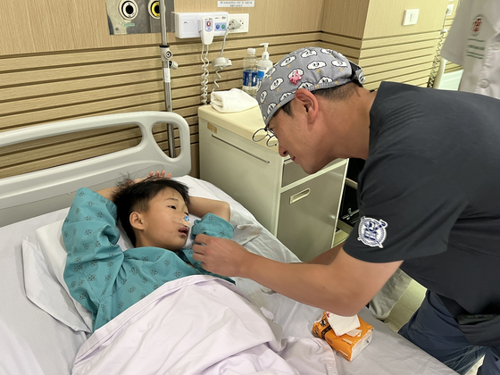 분당서울대병원 성형외과 김백규 교수가 안면기형 수술을 받은 어린이의 경과를 살펴보고 있다. 