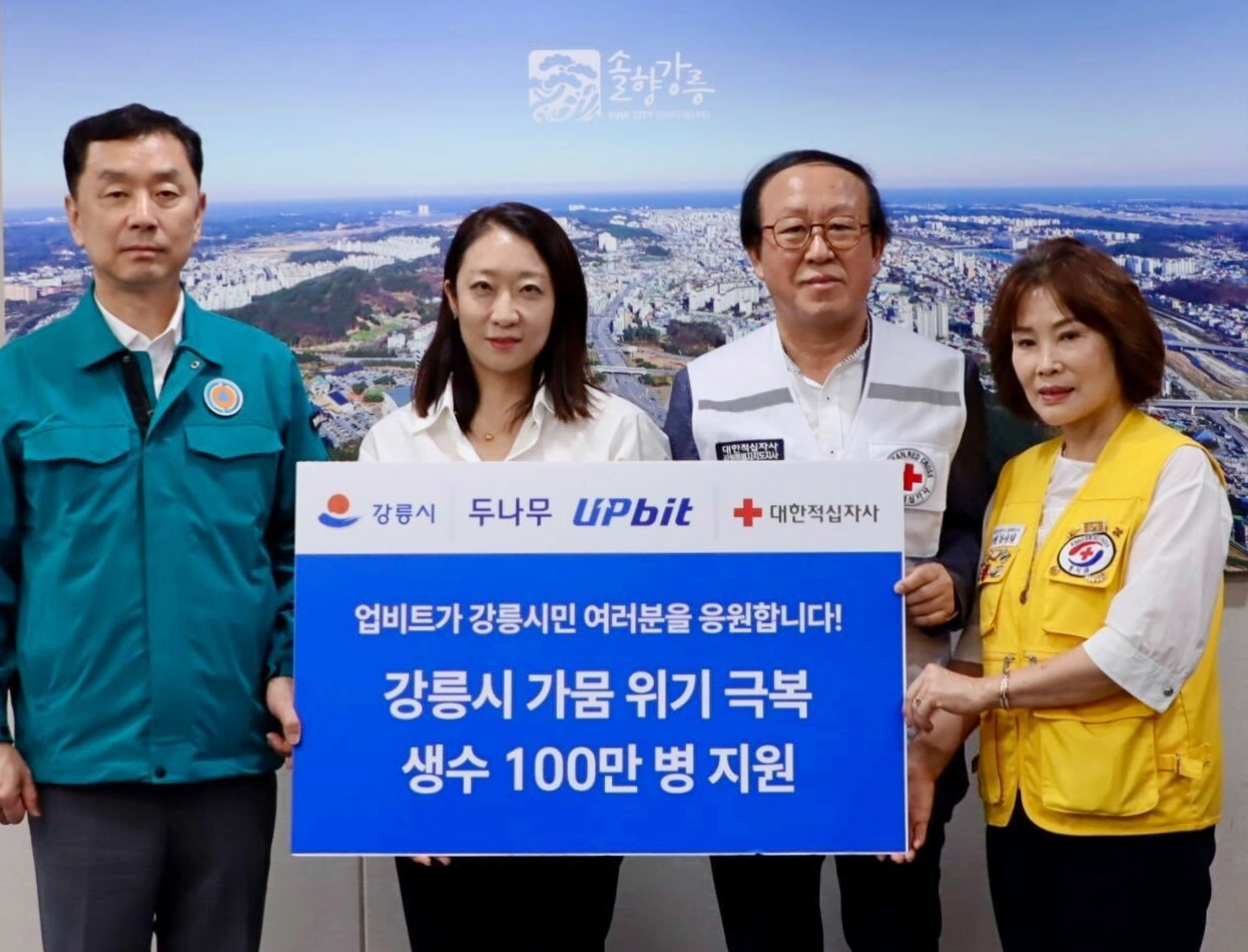 업비트가 강릉시에 생수 100만병을 기부하고 강릉시청·대한적십자사 관계자들과 기념 촬영을 하고 있다.