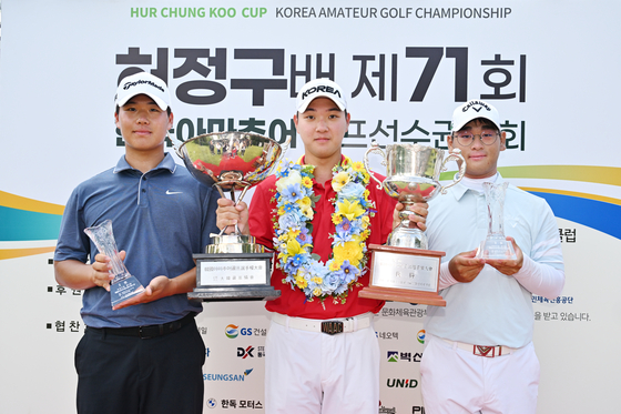 김민수(가운데)가 5일 허정구배 제71회 한국 아마추어 골프 선수권대회를 제패한 뒤 한국 아마추어 순회배(왼쪽)와 허정구배 트로피를 들어 올리고 있다. 왼쪽은 준우승자 안해천, 오른쪽은 3위 임태영. 사진 삼양인터내셔날