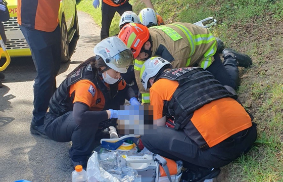 5일 오전 경남소방본부 소속 구급대원들이 거제시 한 골프장에서 발생한 살인 사건 당시 자해한 50대 피의자 A씨와 심정지 상태인 피해자 B씨에게 응급처치를 하고 있다. 사진 경남소방본부