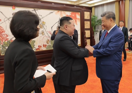 중앙TV가 공개한 김정은 위원장과 시진핑 중국 국가 주석간 북-중 정상회담에 이어 시 주석이 마련한 연회에 참석해 손을 맞잡은 모습. 조선중앙TV 화면=연합뉴스