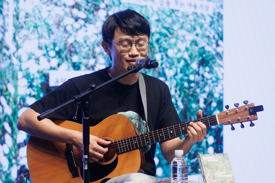 밴드 '브로콜리너마저'의 윤덕원이 2일 서울 종로구 노무현시민센터에서 열린 신간 『열심히 대충 쓰는 사람』 출간 기자간담회에서 책 제목과 동명의 노래를 부르고 있다. 연합뉴스