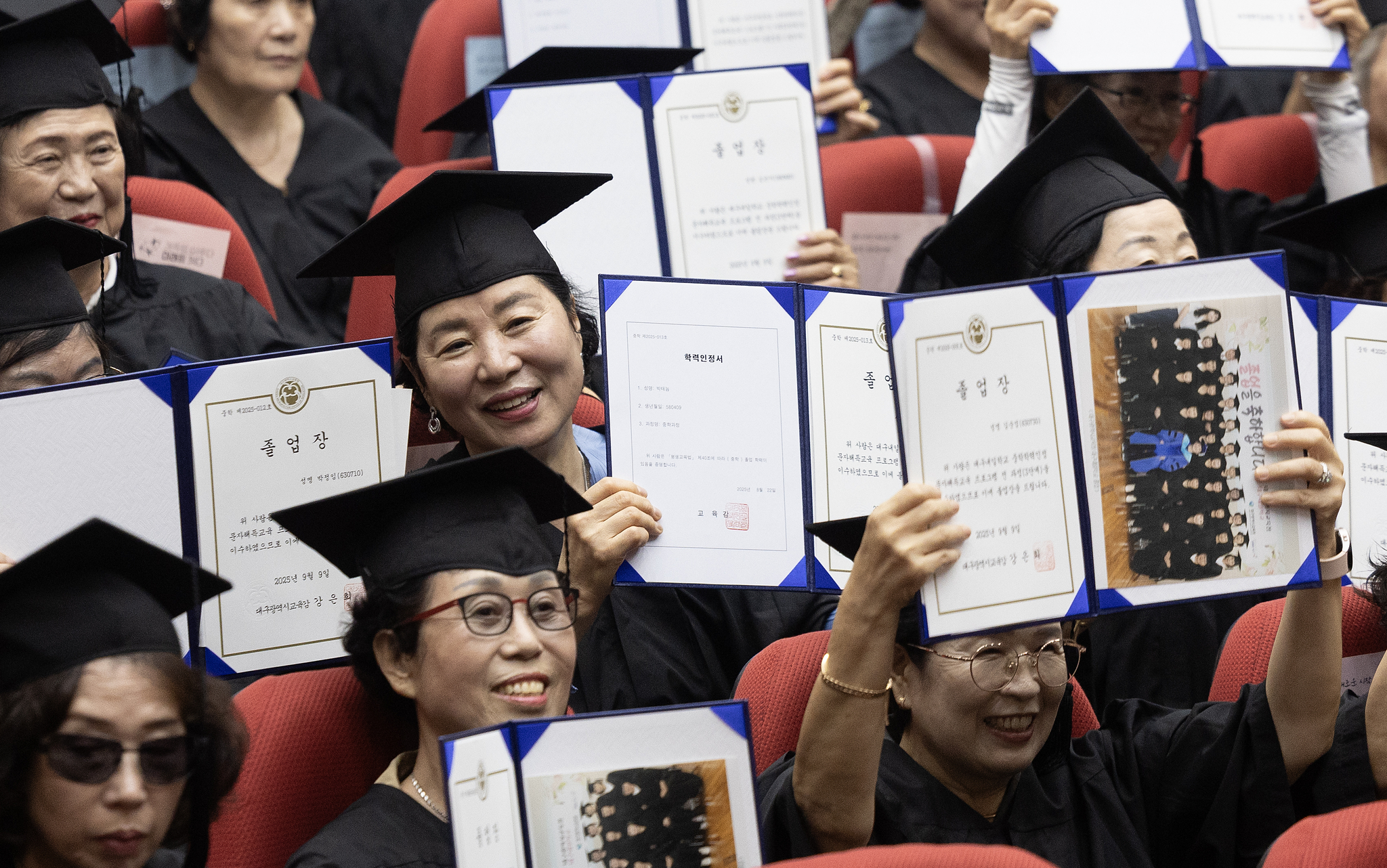 만학도들이 졸업장을 들고 기념 촬영을 하고 있다. 연합뉴스