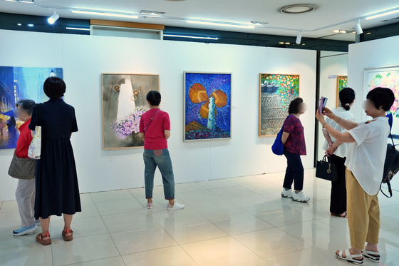 롯데마트 송파점 2층에 있는 상설 미술 전시장 엠아트(mART)센터에서 전시를 보는 방문객들. 사진 롯데마트 