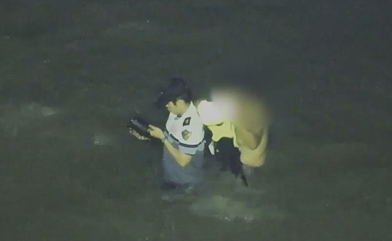 고(故) 이재석 경장이 11일 인천 영흥도 갯벌에서 고립된 70대 중국인에게 구명조끼를 벗어주고 있는 모습. 인천해양경찰서