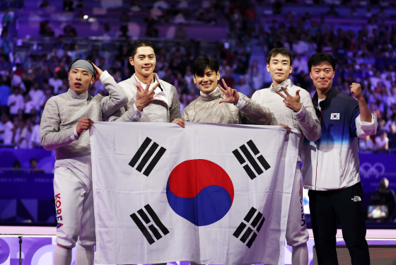 2024파리올림픽 펜싱 남자 사브르 단체전에서 금메달을 차지한 한국 펜싱 대표팀. 왼쪽부터 박상원, 오상욱, 구본길, 도경동이 금메달을 획득한 뒤 태극기를 들고 관중들을 향해 인사하고 있다. 올림픽사진공동취재단