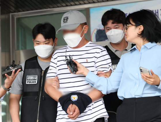 'KT 소액결제 사건' 피의자인 중국 교포 B씨(44)가 18일 경기 수원시 영통구 수원영통경찰서에서 구속 전 피의자 심문(영장실질심사)을 받기 위해 나오고 있다. 뉴스1
