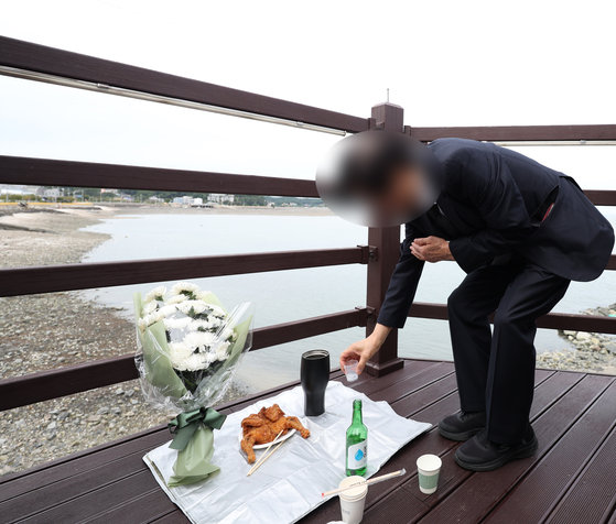 이재석 경사의 유족이 22일 오후 하늘고래 전망대에서 생전 고인이 좋아하던 커피와 치킨을 차려놓고 추모식을 하고 있다. 연합뉴스