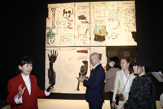 22일 오전 서울 동대문디자인플라자에서 '장 미셀 바스키아 : 과거와 미래를 잇는 상징적 기호들' 특별전 프레스 투어에서 바스키아 최대 작품 '육체와 영혼'(1982~83)을 설명 중인 숨 프로젝트 이지윤 총괄감독(왼쪽부터)과 기획자 디터 부흐하르트, 안나 카리나 호프바우어. 전민규 기자