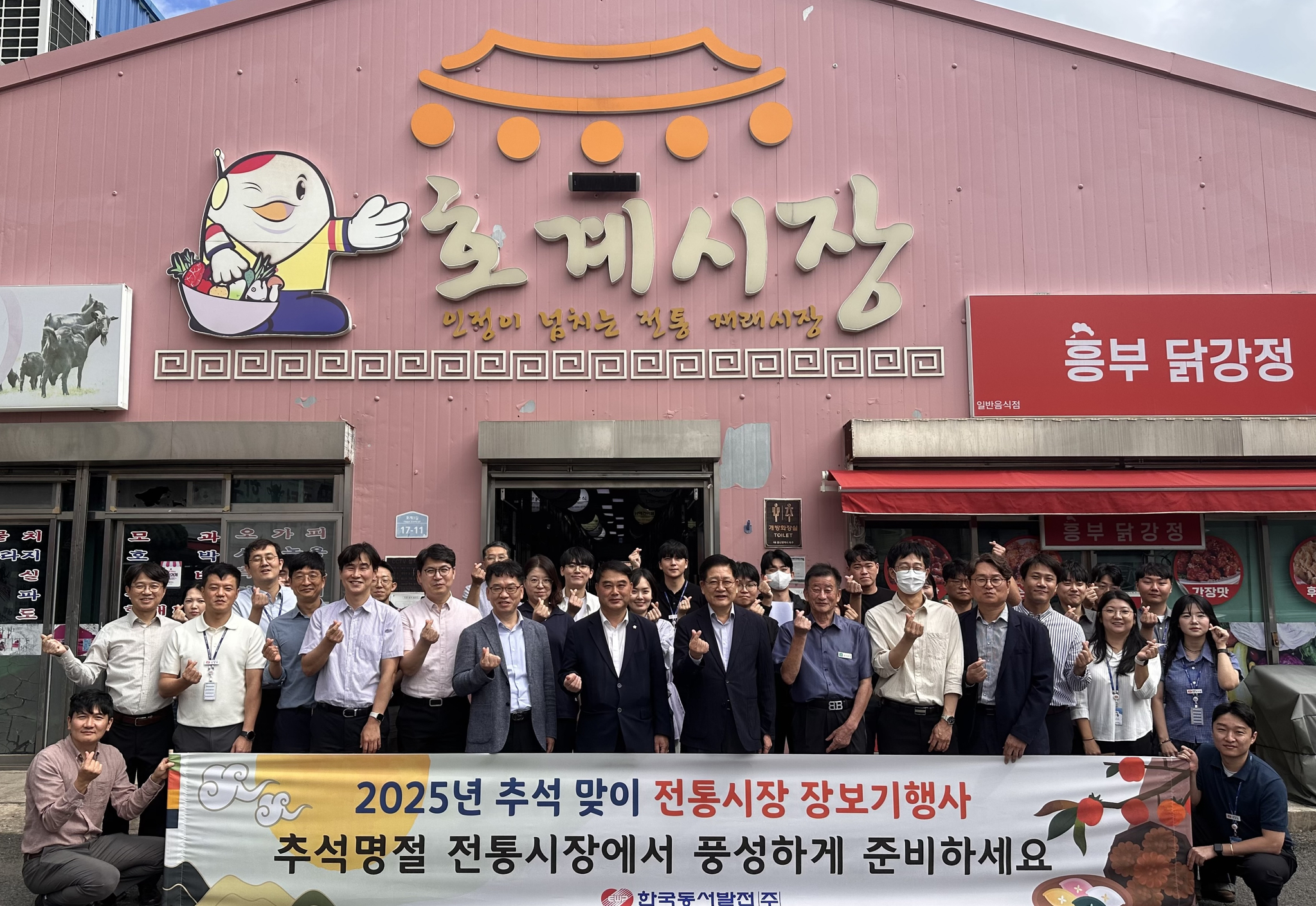 한국동서발전 권명호 사장 및 임직원들이 울산 북구 호계시장에서 전통시장 장보기 행사를 진행하며 기념사진을 찍고 있다.