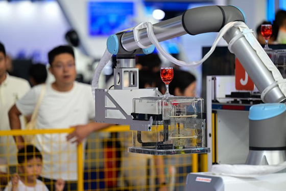 9월 21일 '2025 세계제조업대회' 스마트 로봇 전시구역에서 산업용 로봇이 컵을 집었다 놓는 동작을 시연하고 있다. 신화통신