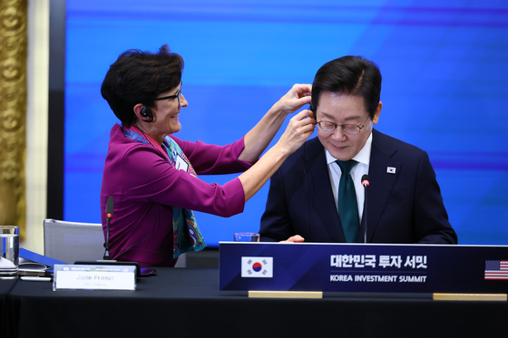  이재명 대통령이 25일(현지시간) 미국 뉴욕 증권거래소에서 열린 한국경제설명회 투자서밋에서 제인 프레이저 씨티그룹 회장의 도움을 받아 통역기를 착용하고 있다. 김현동 기자