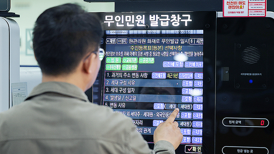 29일 오전 서울 종로구청에서 이용이 중단됐던 무인민원발급기가 복구돼 직원이 주민등록등본 발급을 시연하고 있다. 뉴스1