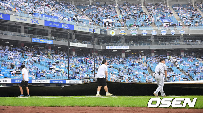 [OSEN=대구, 이석우 기자] 7일 대구 삼성라이온즈파크에서 2025 신한 SOL뱅크 KBO 와일드카드 결정전 삼성 라이온즈와 NC 다이노스의 경기가 열린다. 홈팀 삼성은 로건이 방문팀 NC는 원태인이 선발 투수로 출전한다.갑자기 비가 내리자 관계자들이 방수포를 덮고 있다. 2025.10.07 / foto0307@osen.co.kr