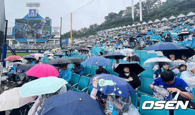 [OSEN=대구, 이석우 기자] 7일 대구 삼성라이온즈파크에서 2025 신한 SOL뱅크 KBO 와일드카드 결정전 삼성 라이온즈와 NC 다이노스의 경기가 열린다. 홈팀 삼성은 로건이 방문팀 NC는 원태인이 선발 투수로 출전한다.갑자기 비가 내리자 팬들이 우산을 쓰고 지연된 경기 개시를 기다리고 있다. 2025.10.07 / foto0307@osen.co.kr