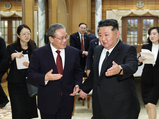 9일 김정은(오른쪽) 북한 국무위원장이 리창(왼쪽 두번째) 중국 국무원(정부) 총리와 회담장으로 들어서고 있다. 이 사진은 10일자 중국공산당 기관지 인민일보 1면에 실렸다. 신화통신