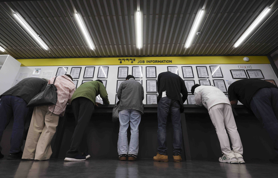 서부고용복지플러스센터 일자리 정보 게시판 앞에서 구직자들이 이력서를 작성하고 있다. 뉴시스