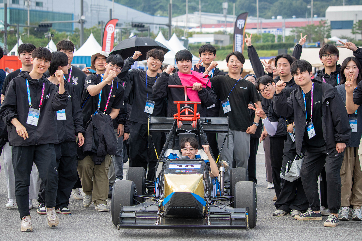 한국공학대학교 자작자동차팀 Team NSSUR가 2025 KSAE 대학생 자작자동차대회 FORMULA 부문에 참가해 ‘알테어 최적설계상’을 수상한 모습. 팀원들은 자작 포뮬러 차량의 주행 및 시상식에 함께하며 최적화 설계 역량을 입증했다.