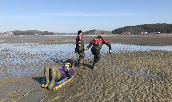 보령해경 경찰관들이 충남 서천의 갯벌에 고립된 여성을 구조하고 있다. [사진 보령해경]