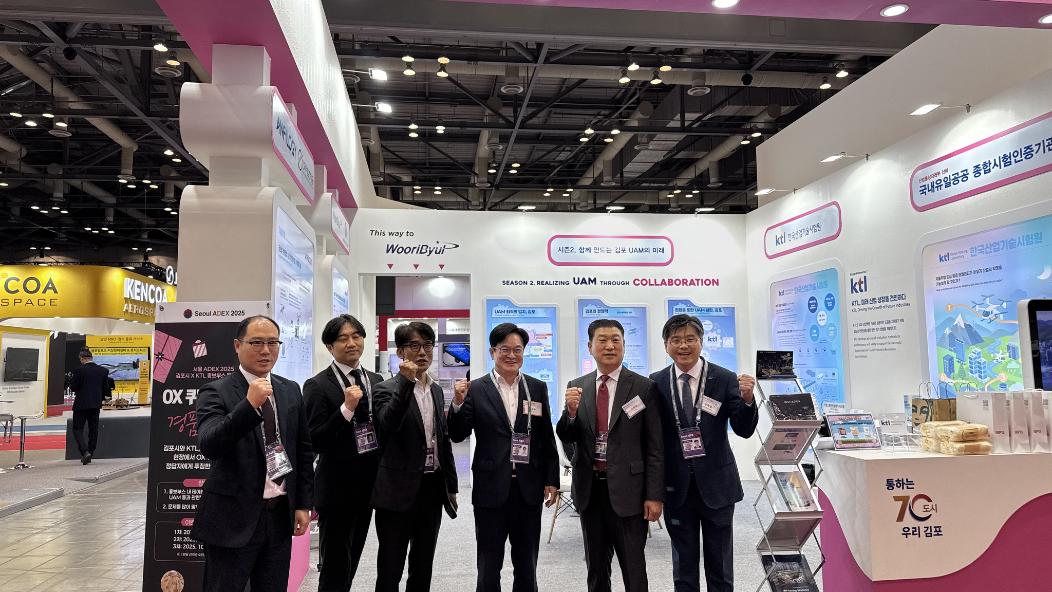 KTL, 김포시 관계자들이 ADEX 2025 공동관 앞에서 기념사진을 촬영하고 있다. (왼쪽부터) KTL 권종원 산업인공지능혁신센터장, KTL 이건원 미래항공기술센터장, 김포시 김광식 미래전략과장, 김병수 김포시장, 이정석 우리별 대표, KTL 송태승 디지털산업본부장