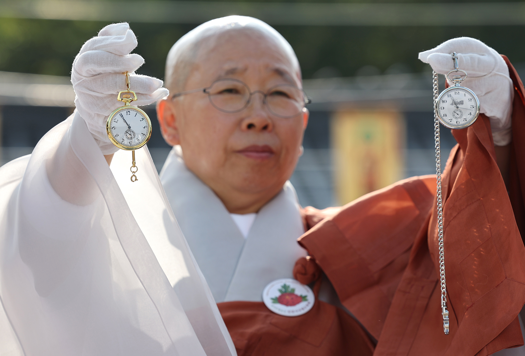 진관사 주지 법해스님이 25일 김진 광복회 부회장에게 받은 김구 선생과 윤봉길 의사가 교환했던 회중시계 복각을 들어보이고 있다. 김경록 기자