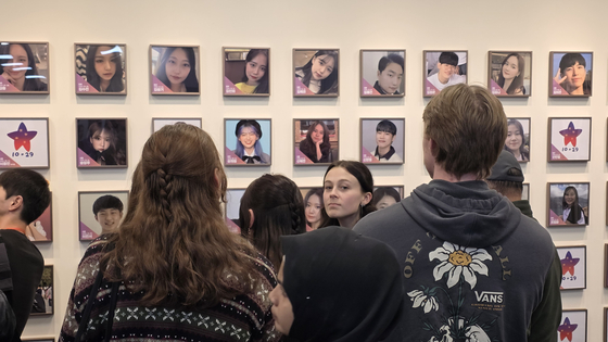 26일 서울 종로구 ‘10·29 이태원 참사 기억소통공간’ 별들의집에서 외국인 유가족이 벽에 걸린 희생자 사진을 보고 있다. 김창용 기자
