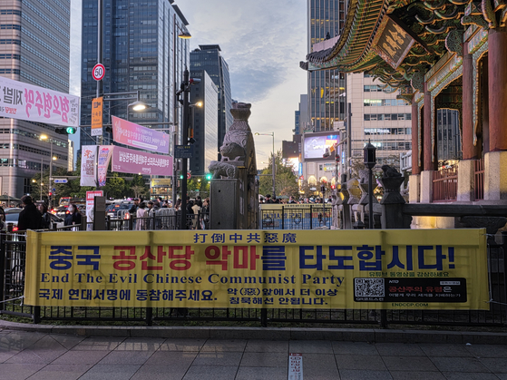지난 25일 서울 광화문역 4번 출구 고종 칭경기념비 곁에 파룬궁이 혐중 문구 현수막을 걸었다. 이영근 기자