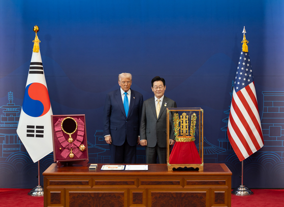이재명 대통령이 29일 경북 경주박물관에서 열린 한미 공식 환영식에서 도널드 트럼프 미국 대통령에게 무궁화 대훈장 수여와 천마총 금관 모형을 선물하고 있다. 사진 대통령실 제공