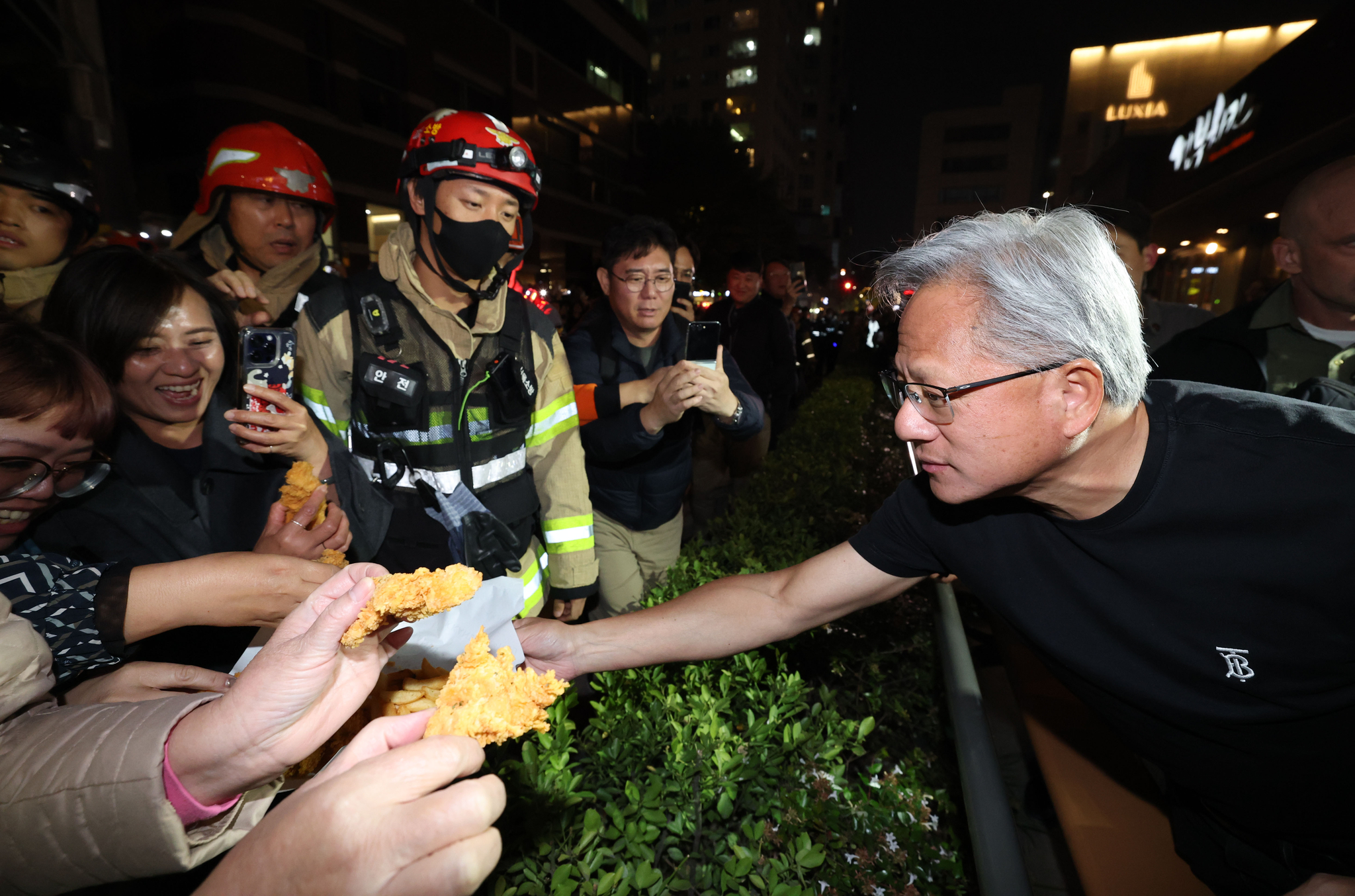 젠슨 황 엔비디아 최고경영자가 30일 서울 삼성동 한 치킨집에서 진행된 이재용 삼성전자 회장, 정의선 현대차그룹 회장과 치맥 회동 중 시민에게 치킨과 감자튀김을 나눠주고 있다. 김경록 기자