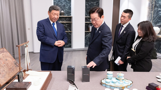 이재명 대통령이 1일 시진핑 중국 국가주석이 선물한 샤오미 스마트폰을 살펴보고 있다. 사진 대통령실